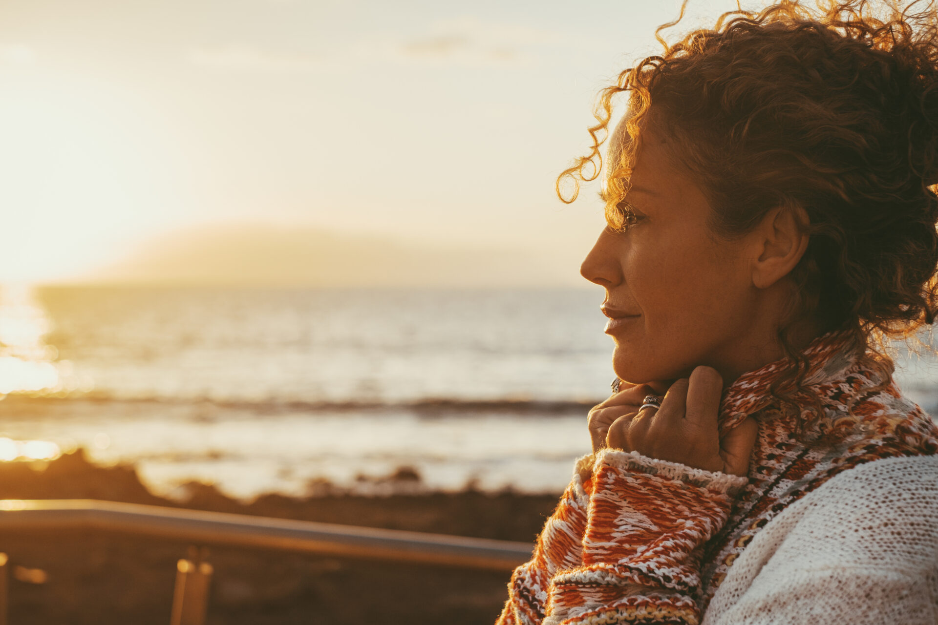 Enjoyed and serene lady dreaming and thinking outdoor with ocean beach and sunset light in background. Concept of happy lifestyle female people in outdoor leisure. Love and peace concept day