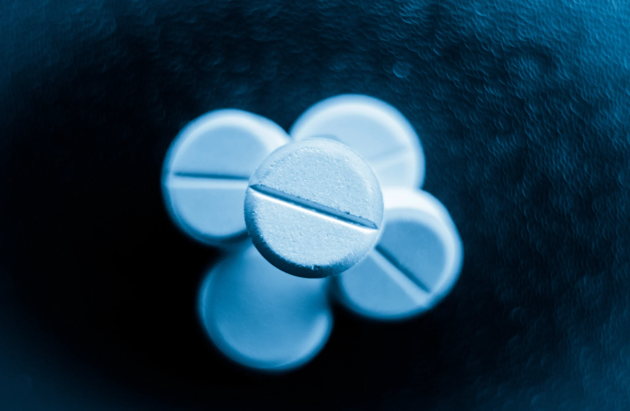 Blue roxicodone or roxicet pills on a black background