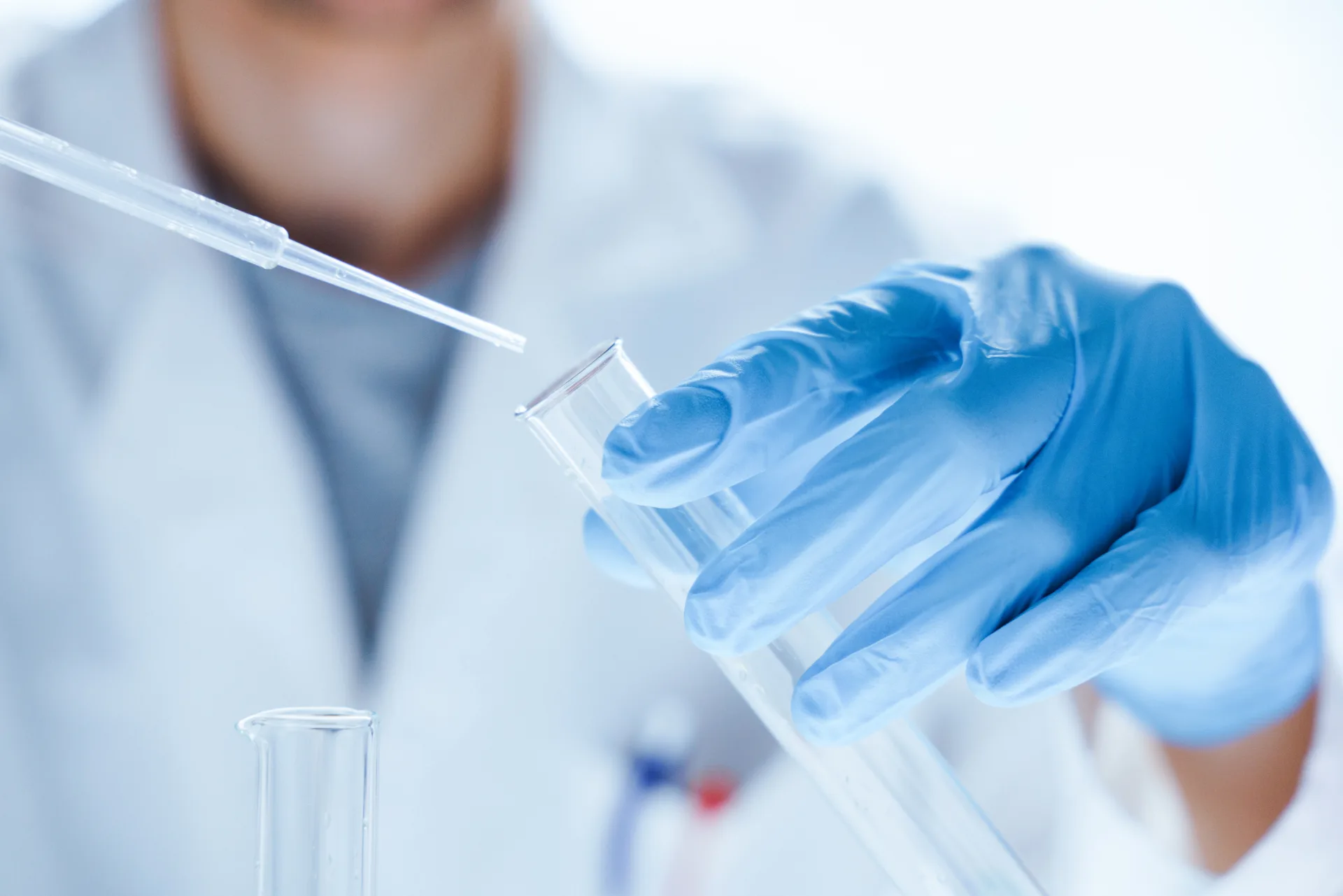 Picture of a gloved hand holding a test tube and a pipette for an EtG test