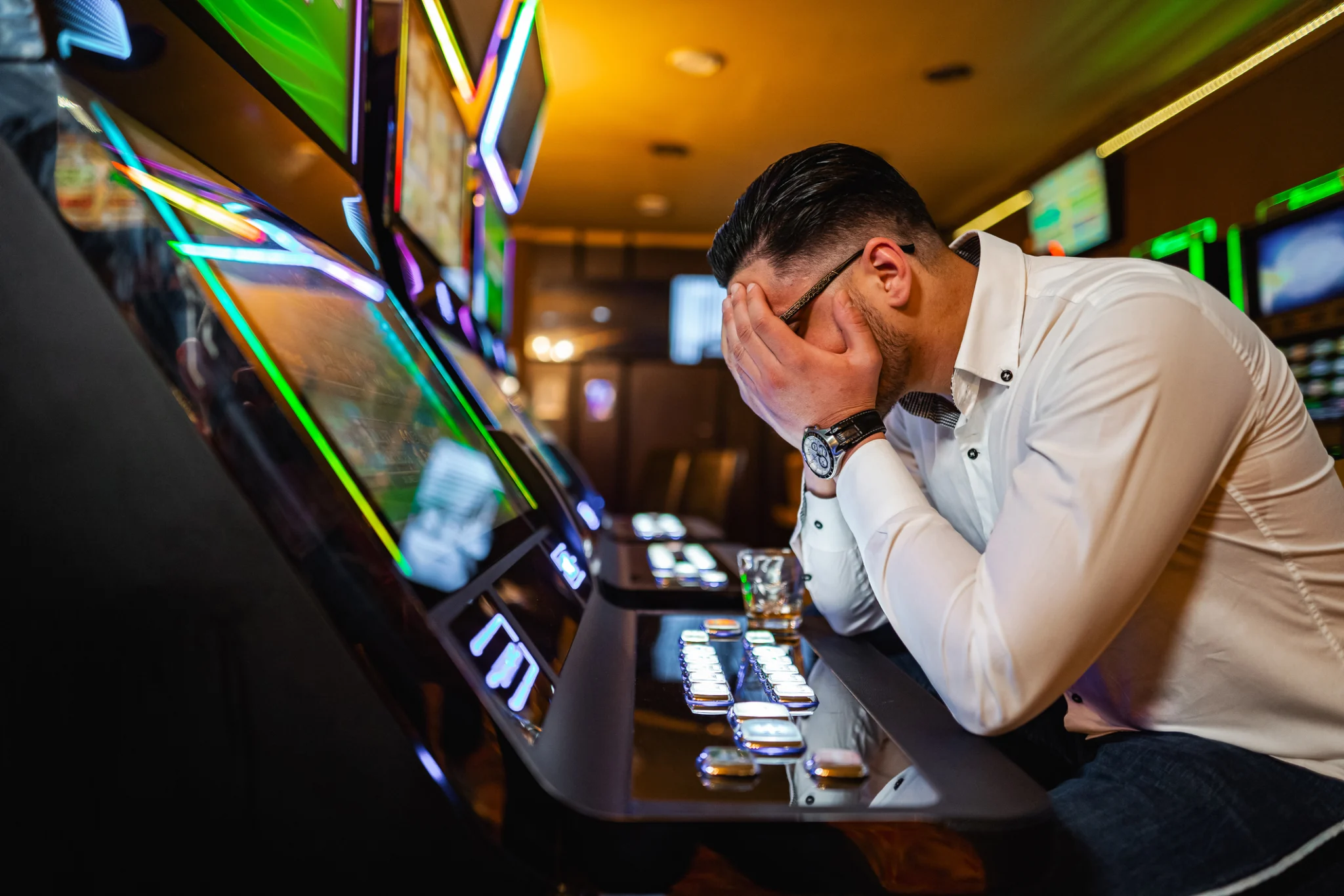 Men loosing his money on slot machine in the casino.