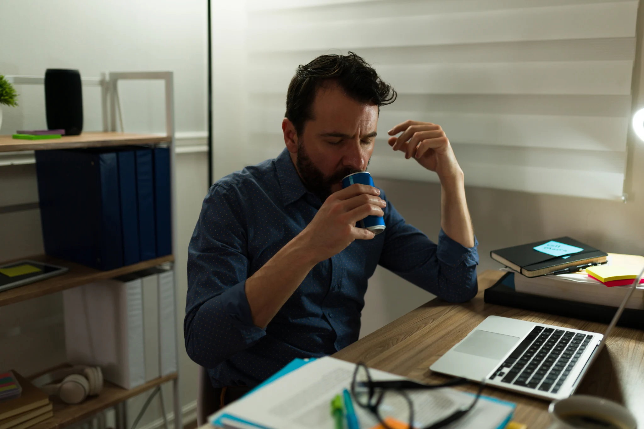 Caucasian man sitting at desk working drinking Feel Free energy drink